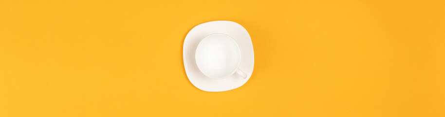 Empty coffee or tea cup isolated on yellow. Top view. Copy space