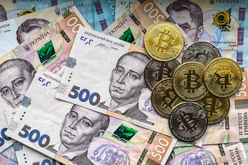 coins of Bitcoin on one thousand Ukrainian hryvnias. Electronic decentralized money concept.