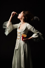 vintage style woman with closed eyes eating french fries isolated on black