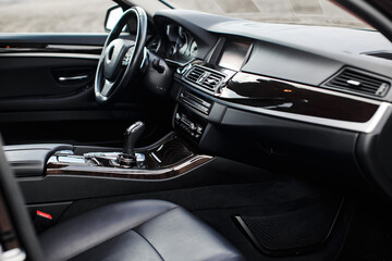 Fototapeta na wymiar Luxury modern car Interior. Steering wheel, black leather seats, shift lever and dashboard.