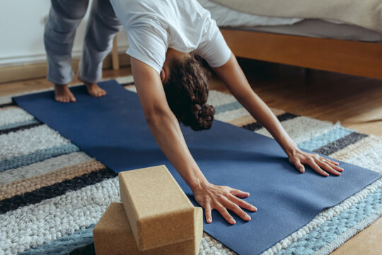 Frau macht Yoga zuhause im Schlafzimmer
