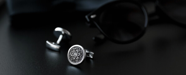 Obraz na płótnie Canvas luxury men's cufflinks with sunglasses on black background.