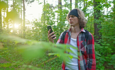 Man with smartphone lost in the forest.