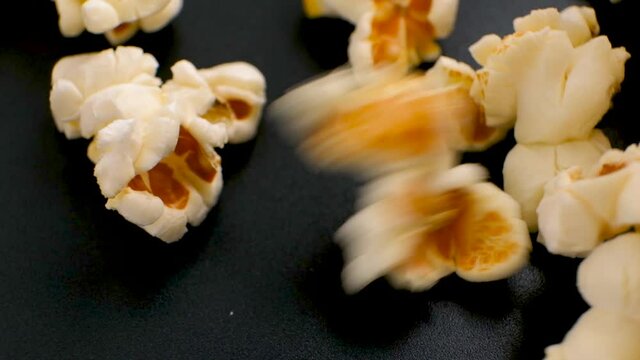 Fresh popcorn fall down to the black plate in Slow Motion