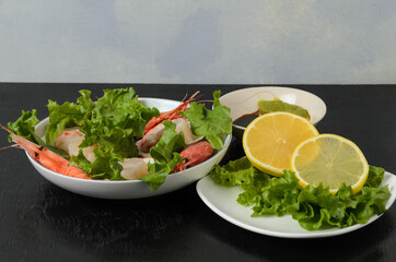 Natural raw scallop with boiled shrimp in the sink in a ceramic bowl with lettuce leaves and sauce on a dark background.