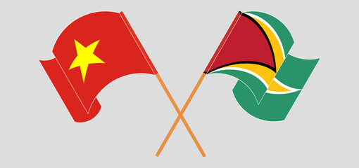 Crossed and waving flags of Vietnam and Guyana