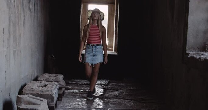 A Long Shot of a Blonde Young Woman Walking Inside an Ancient Ruins 