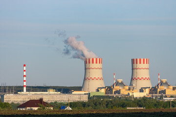 Nuclear power plant emissions of steam in the air atmosphere. Industrial zone with power station...