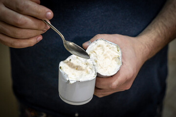The man cut a can of cream and eats the remnants of the cream. Damaged spray of cream