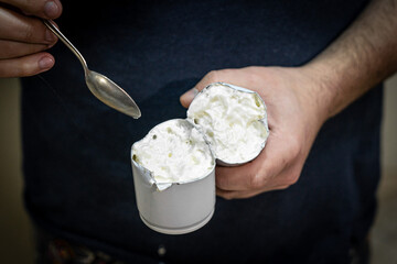 The man cut a can of cream and eats the remnants of the cream. Damaged spray of cream