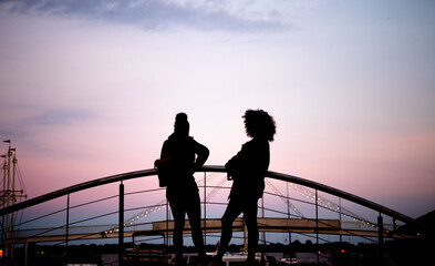 silhouette of people on the bridge in the evening