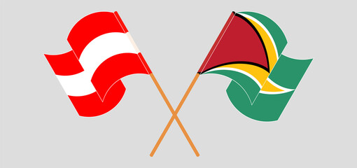 Crossed and waving flags of Austria and Guyana