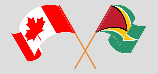 Crossed and waving flags of Canada and Guyana