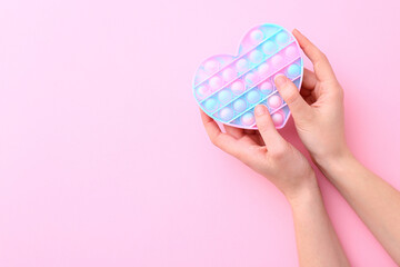 Colorful antistress silicone toy fidget push pop it on pink background