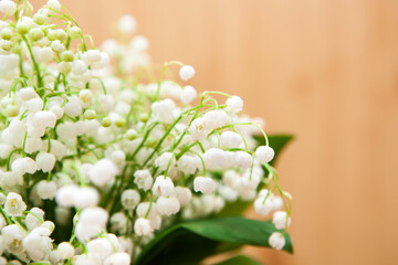 Bouquet of lily of the valley flowers on wooden background, beautiful card