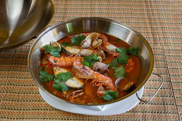 Traditional portuguese seafood dish cataplana. The main ingredients are sea shellfish, shrimp and green vegetables. Top view