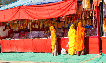 Pushkar, India - November 10, 2016: Bunch of women in traditional hindu wear saree buying or...