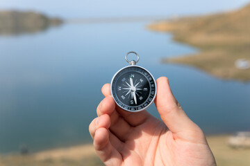 man holding compass in lake