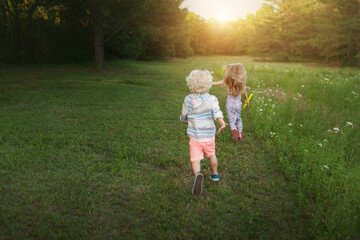 Brother and Sister Running in Field 