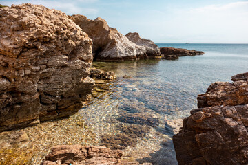 Wild mediterranean sea with rocky shore and blue crystal clear water. Travel Greece near Athens. Summer nature scenic lagoon