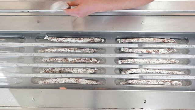 Sausages. Packing line of sausages Fuet is a Catalan thin, cured, dry sausage of pork meat in a pork gut . Industrial manufacture of sausage products. High quality 4k footage