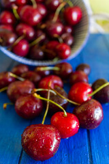 Fresh red cherries with water drops on white wooden table