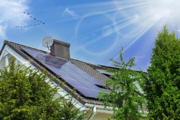 Solar panels on the roof. Beautiful modern house and solar energy. Nature sun rays and trees.