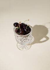 Sweet cherries in a crystal bowl, minimal modern concept.