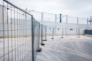 Valencia, Spain - June 9, 2021: Temporary walls and metal fences separate a new industrial...