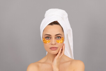 young woman with terry towel use facial golden eye patch for skin, skincare