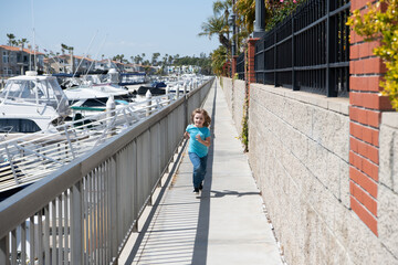 Active boy kid enjoy summer holidays running on promenade, fun