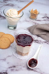 sweet desserts chocotorta and chiskey with cookies sweet milk and red fruit jam in glasses on light marble countertops