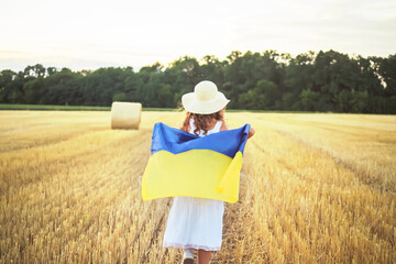 Patriotic holiday. Happy children girl with Ukrainian flag outdoors. Ukraine celebrate 24th of August. Flag Day. Constitution day. Copy space.