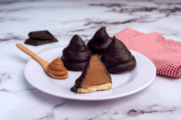 Chocolate covered dulce de leche glasses with a glass open in half on the counter and squared napkin