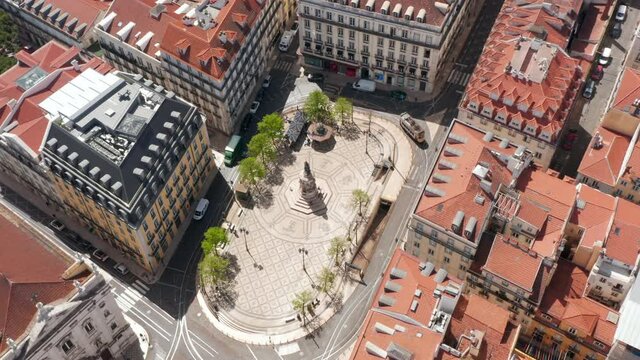 Aerial view of small oval square with ornamental pattern on tiled pavement and statue in center. B13 Square from drone. Lisbon, capital of Portugal.