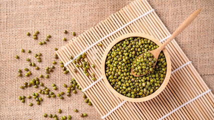 Mung bean seeds in a wooden spoon and bowl, Food ingredients in Asian cuisine and produce mung bean...