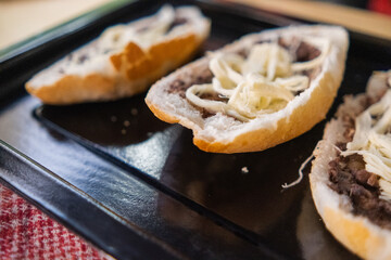 Three traditional Mexican molletes on a black tray