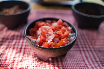 Black bowls of pico de gallo above checkered tablecloth
