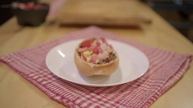 Traditional Mexican mollete on a plate above white and red checkered napkin