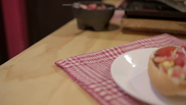 Traditional Mexican mollete on a plate above white and red checkered napkin