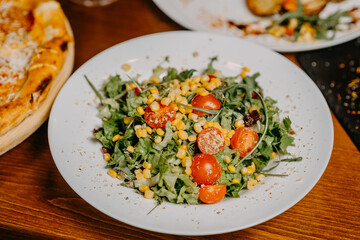 Fresh salad with cucumber  tomato arugula corn and sesame dressing