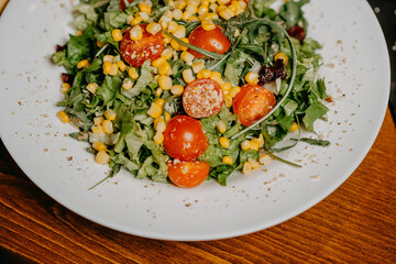 Fresh salad with cucumber  tomato arugula corn and sesame dressing