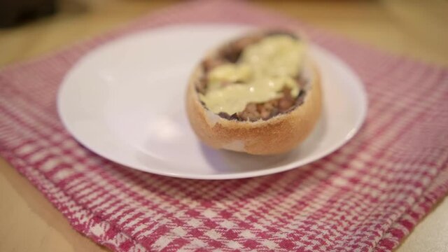 Spatula placing a traditional Mexican mollete on white plate