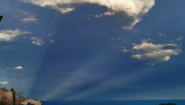 Cielo fantastico all&rsquo;imbrunire con nuvole su scie di luce che partono dal mare come comete