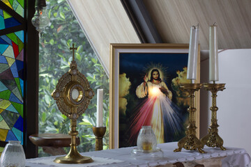 Catholic Eucharistic adoration chapel with Divine Mercy picture of Jesus Christ, candles and holy bread of life - the Blessed Sacrament on the altar. - obrazy, fototapety, plakaty