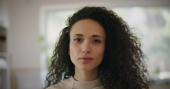 Portrait of a serious looking multi ethnic young woman. Close up, slow motion. 