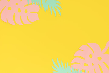 Paper cut leaves of monstera and palm trees on a yellow background with copy space. Tropical paper background.