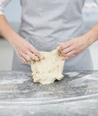 Woman makes dough in the kitchen at home