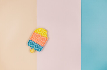 Popular silicone pastel anti stress pop it toy for child on pink background. Trendy Sensory Fidget Toy. Funny Bubble suitable for relieving stress for adults