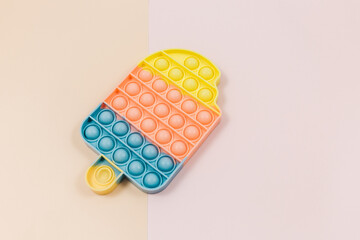 Popular silicone pastel anti stress pop it toy for child on pink background. Trendy Sensory Fidget Toy. Funny Bubble suitable for relieving stress for adults